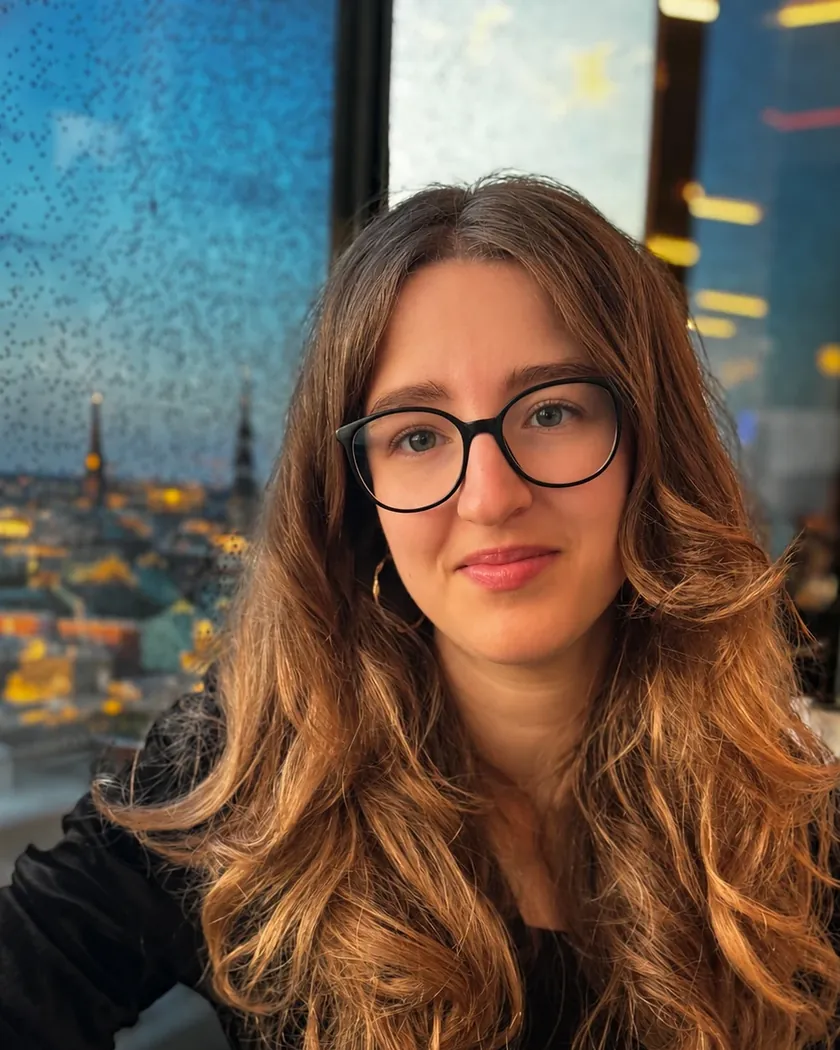Luna Spiegel in einem nahen, warmen Porträt, im Hintergrund eine Stadtskyline im Dämmerlicht.